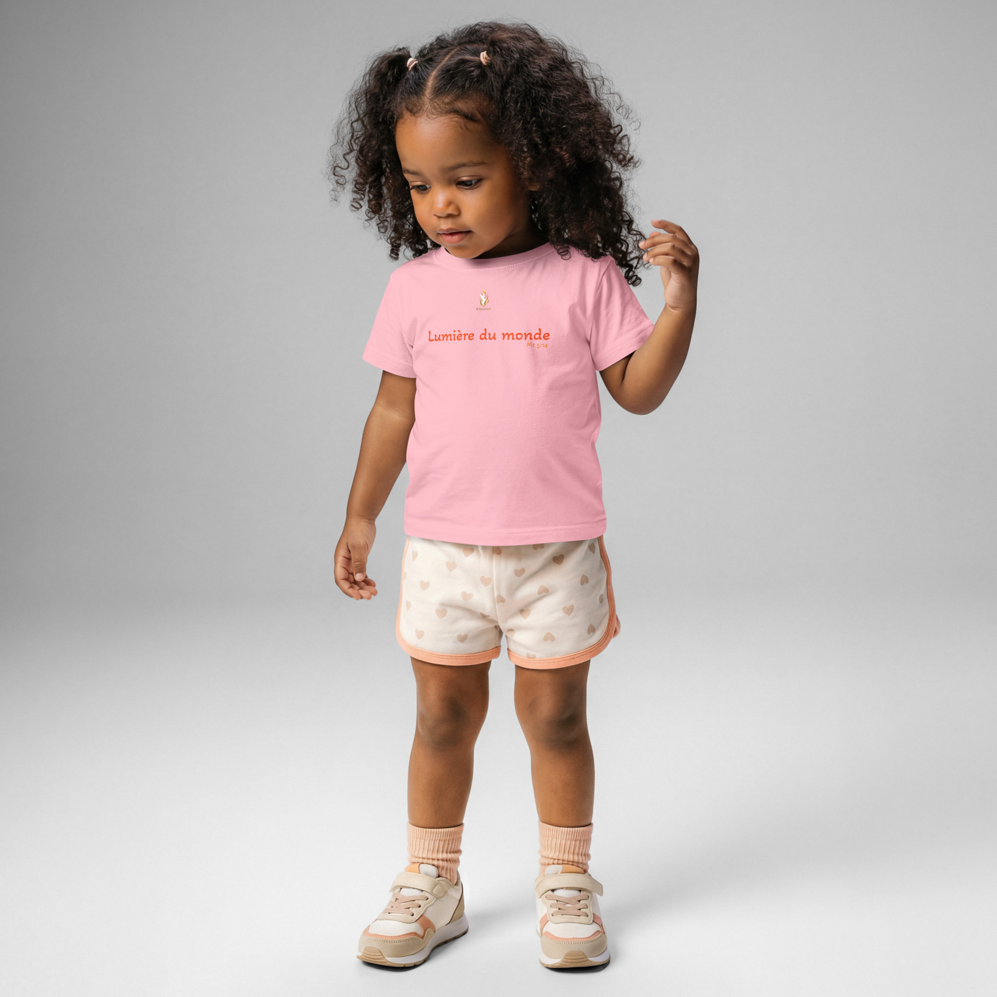 T-shirt bébé KHAWNAN rose, parole « Lumière du monde », vue de face.