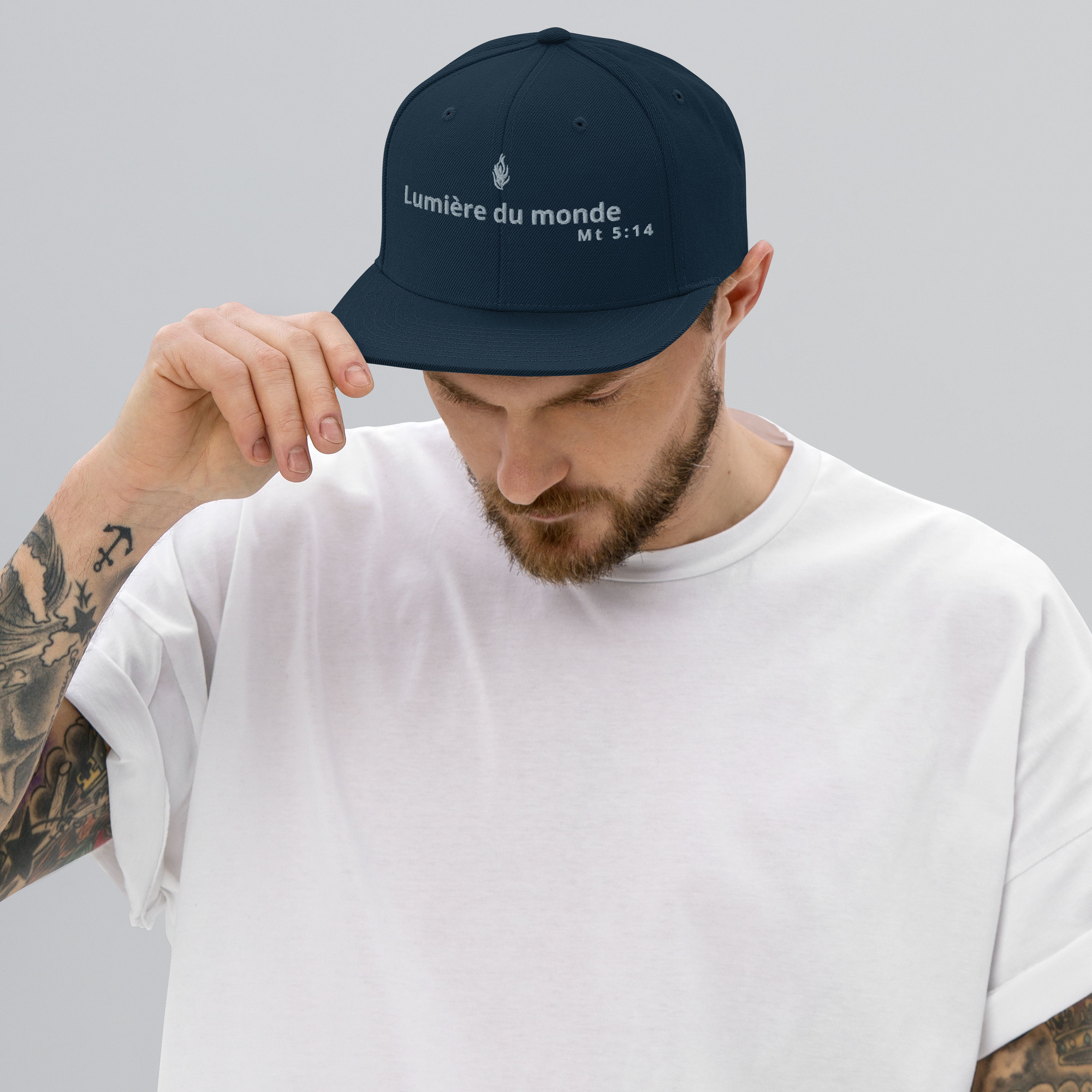 Casquette snapback KHAWNAN bleu marine, parole « Lumière du monde », vue de face.