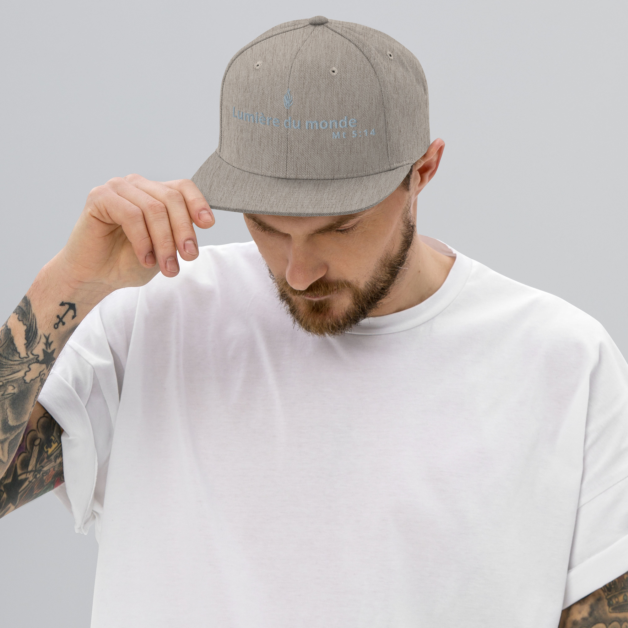 Casquette snapback KHAWNAN gris chiné, parole « Lumière du monde », vue de face.