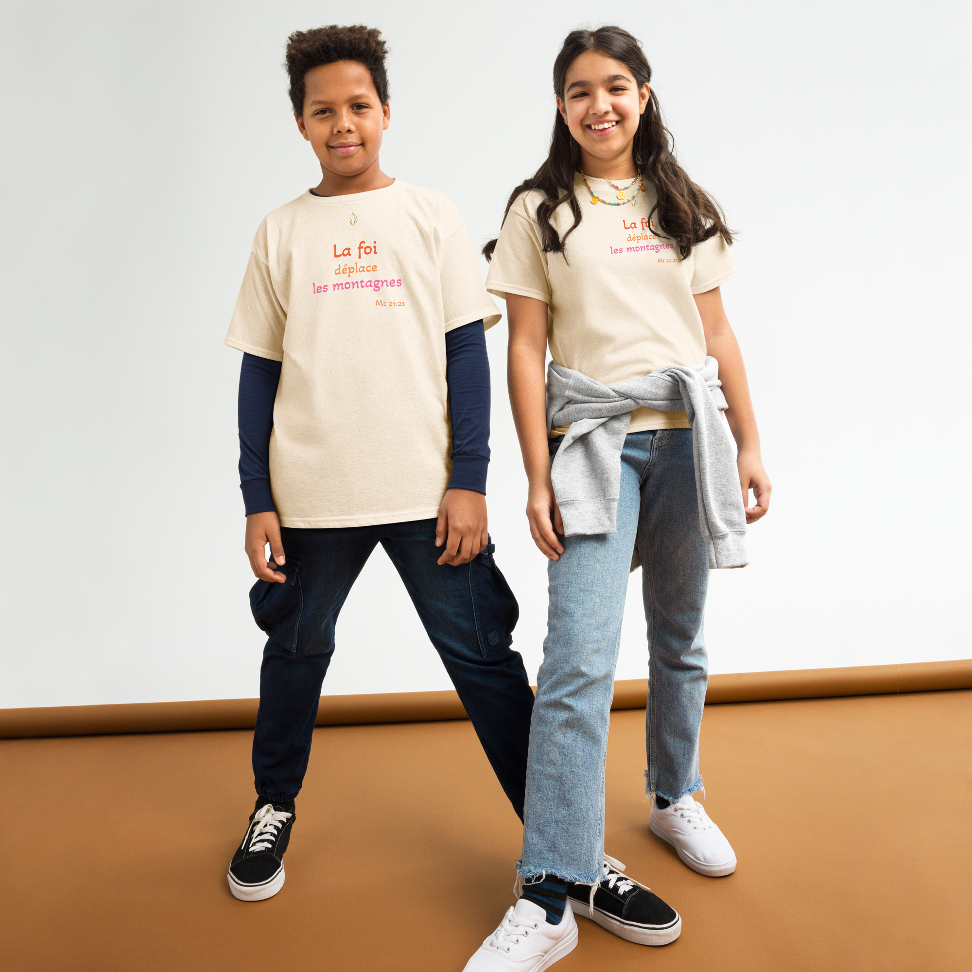 T-shirt classique enfant KHAWNAN beige clair, parole « La foi déplace les montagnes », vue de face.